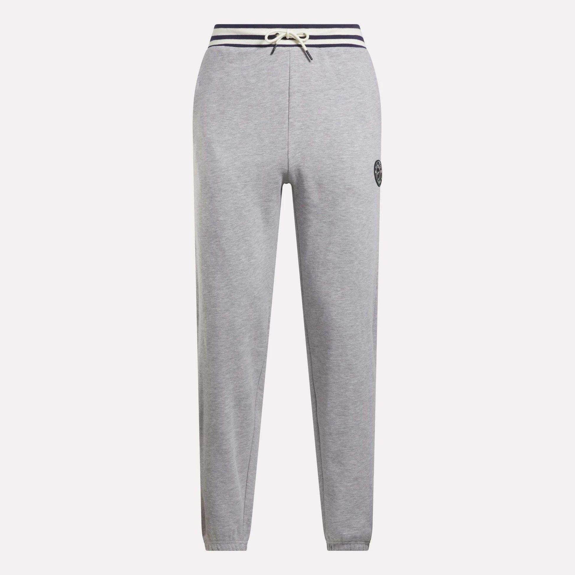 Reebok Men's Lawn Club French Terry Jogger Pants in light gray feature a cotton-blend fabric, navy striped drawstring waistband, straight legs, and a small circular logo on the left thigh. Stylish everyday sporty comfort. Shown on a white background.
