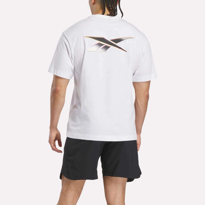 A man is seen from behind wearing a Reebok Men's Athlete Speed Logo T-Shirt featuring a large stylized X logo on the back and black shorts, standing against a plain background.