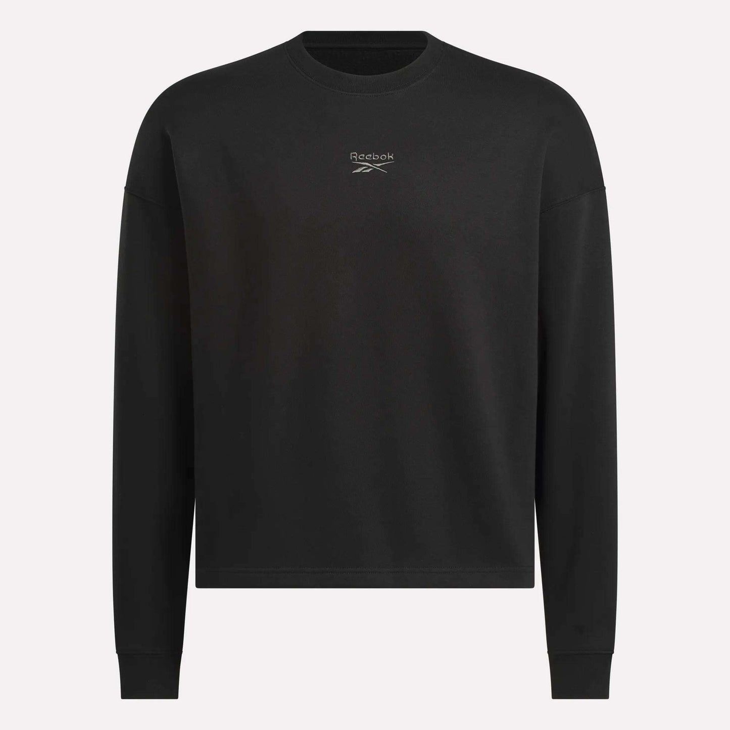 The Men's Wardrobe Essentials Sweatshirt by Reebok is a plain black, relaxed-fit design with long sleeves and a small white logo on the chest. Made from soft cotton-blend fleece. Shown against a light gray background.