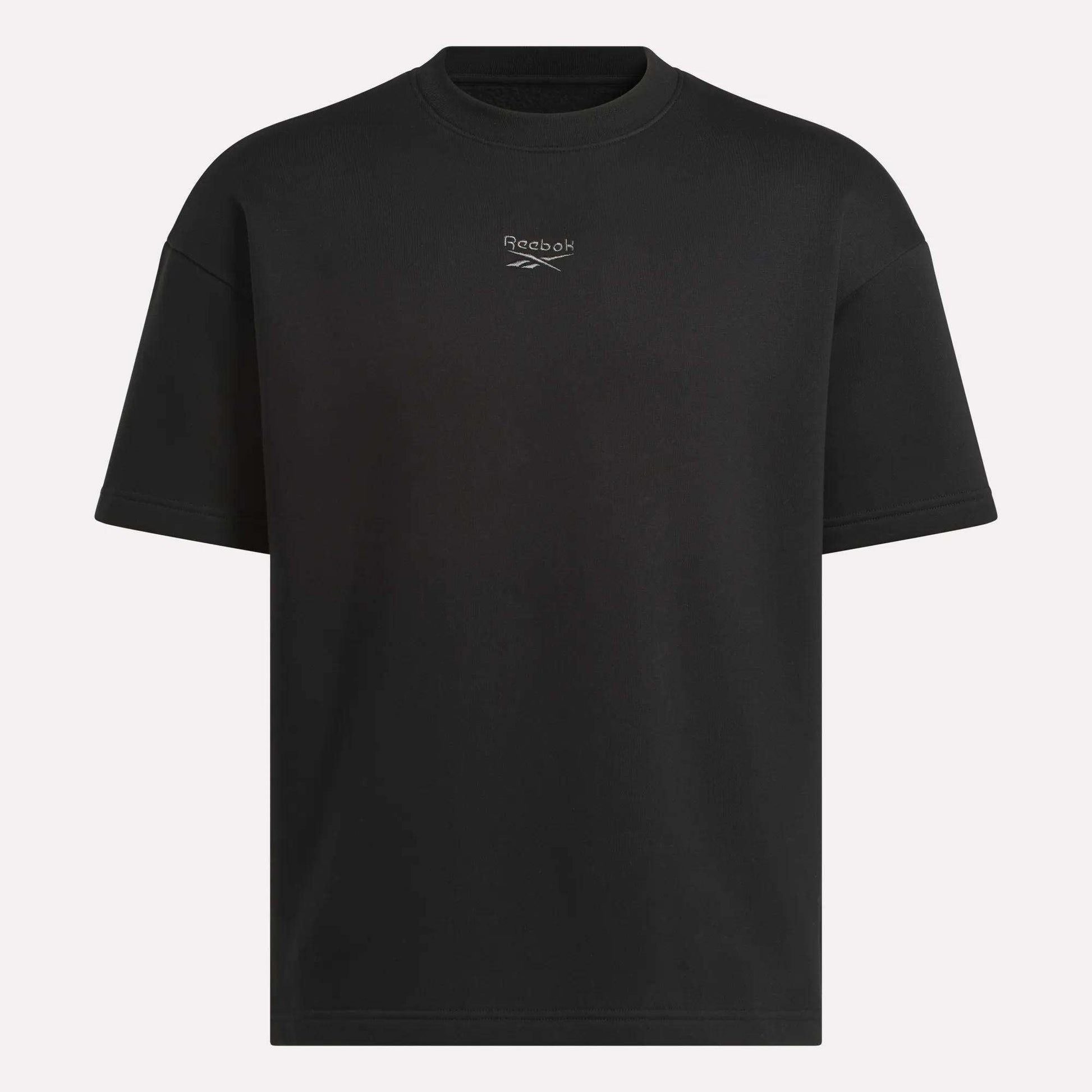 The Reebok Men's Wardrobe Essentials T-Shirt is a plain black crewneck with a small logo and centered text on the chest, offering a relaxed fit and classic style for everyday comfort.