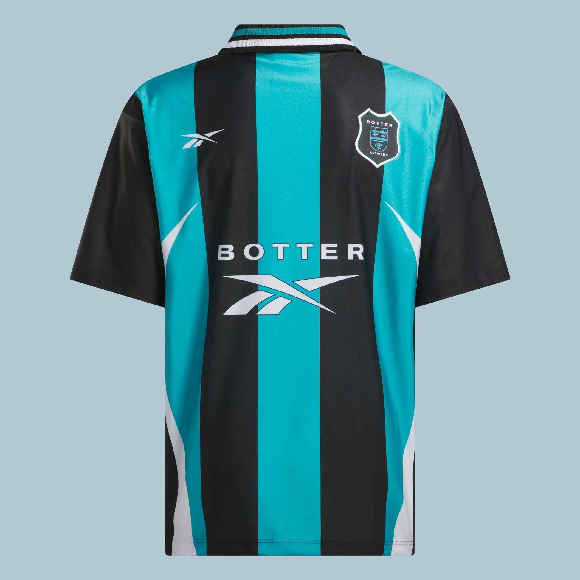 The Reebok x Botter LTD Reverse Soccer Men's Tee features black and teal vertical stripes, a collared design, white side accents, and chest logos including “Botter 1978.” This vintage-inspired jersey merges classic style with Reebok branding.