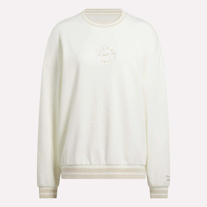 The Women's Lawn Club Crew Sweatshirt by Reebok is a cozy white fleece crewneck with ribbed cuffs and hem, featuring an embroidered circular logo and text on the chest plus a small sleeve logo for subtle style.
