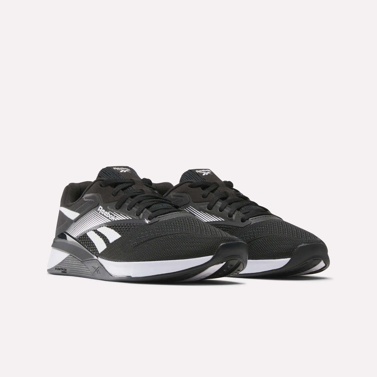 A pair of black Reebok Nano X4 Training Shoes with white accents, mesh uppers, black laces, and logo, shown against a plain light background.