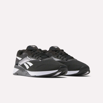 A pair of black Reebok Nano X4 Training Shoes with white accents, mesh uppers, black laces, and logo, shown against a plain light background.