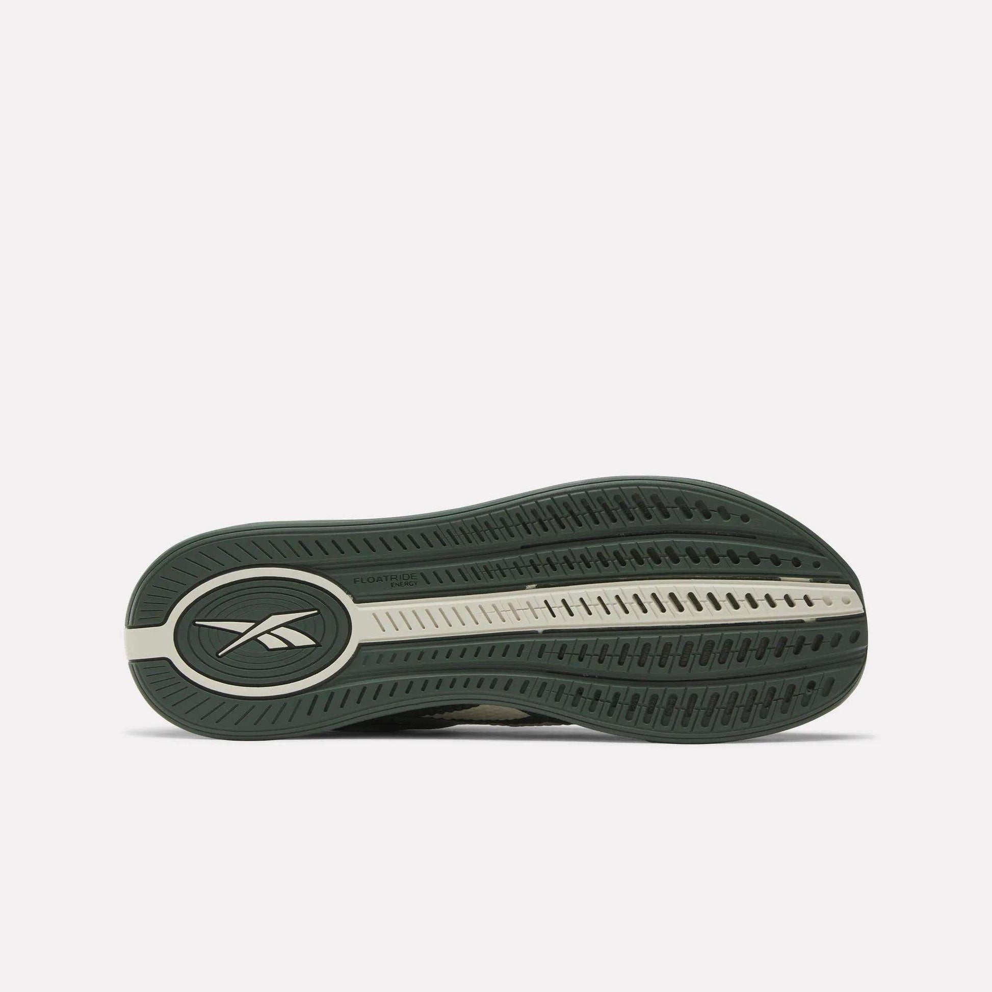 The image shows the green and beige rubber outsole of the Reebok Nano X4 Training Shoes, featuring an oval Reebok logo near the heel, a textured tread for grip, and lightweight Floatride Energy Foam cushioning.