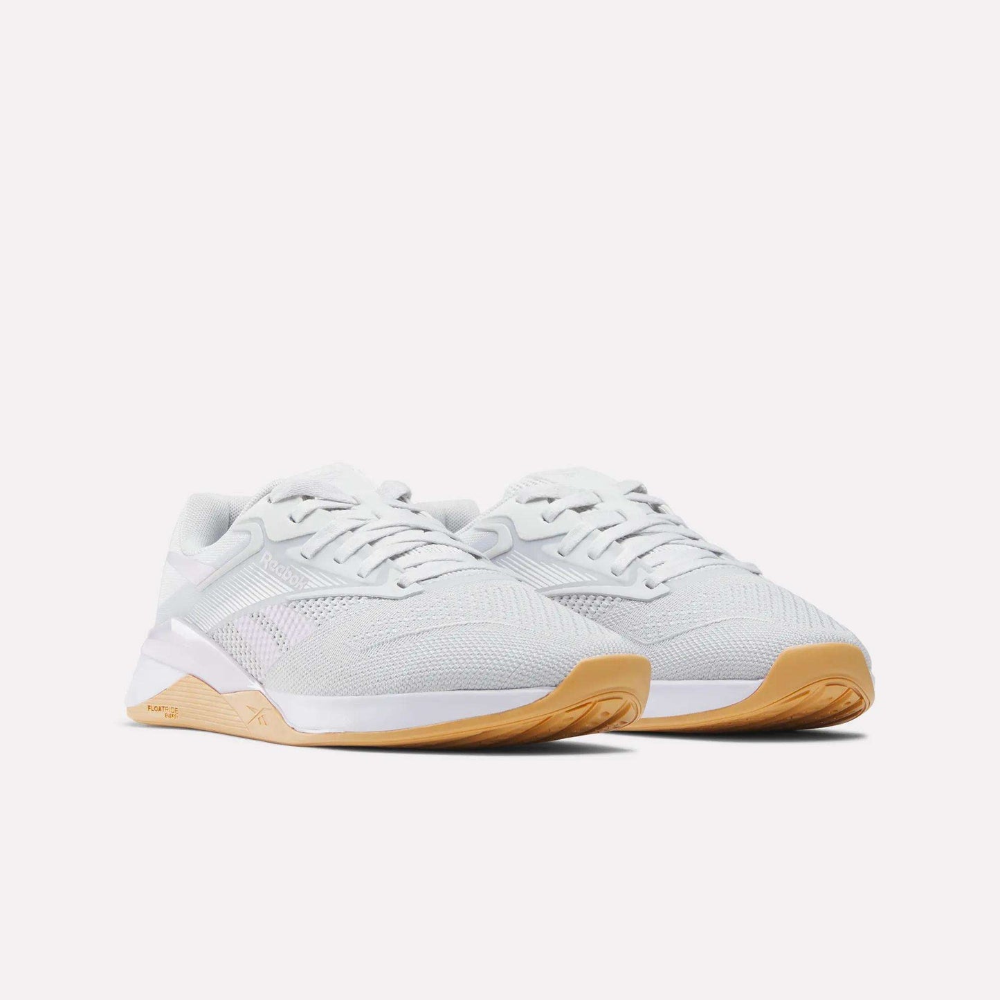 The Reebok Women's Nano X4 Training Shoes feature breathable mesh uppers, white laces, and light brown gum soles with Floatride Energy Foam, shown on a white background.