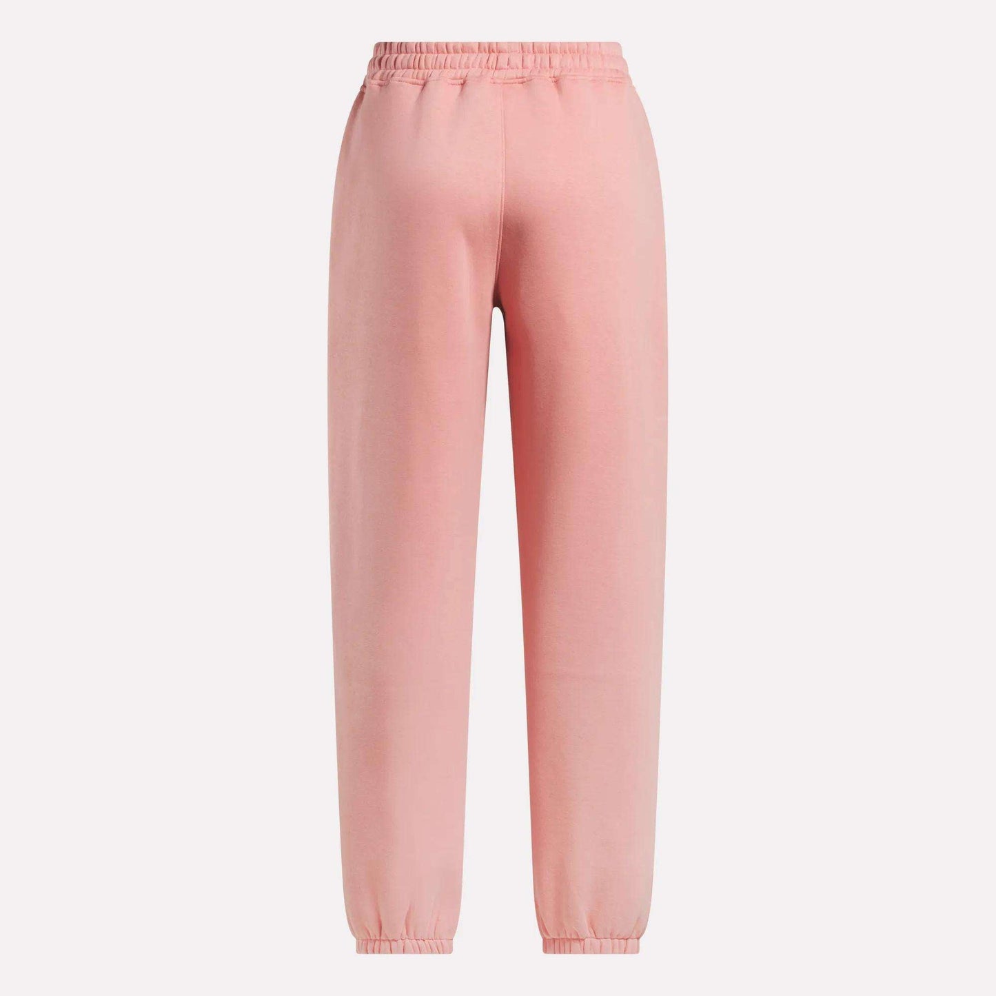 The Reebok Women's Wardrobe Essentials Sweat Pants in light pink feature an elastic waistband, ankle cuffs, and soft fleece material, shown against a plain white background.