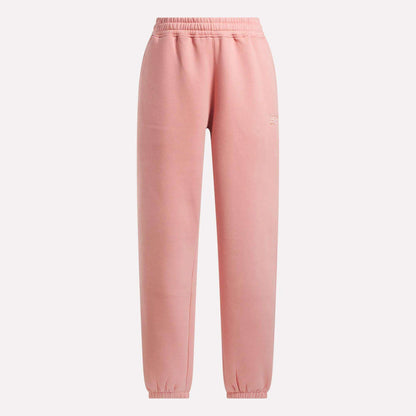 Reebok Women's Wardrobe Essentials Sweat Pants in soft pink, with an elastic waistband and ankle cuffs, shown on a plain white background.