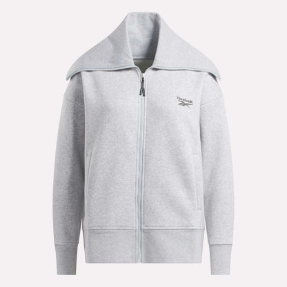 The Reebok Women's Wardrobe Essentials Retro Zip Top is a light gray fleece sweatshirt with a wide collar, long sleeves, and a minimalistic design. It features the Reebok logo on the left chest. Shown against a plain white background.