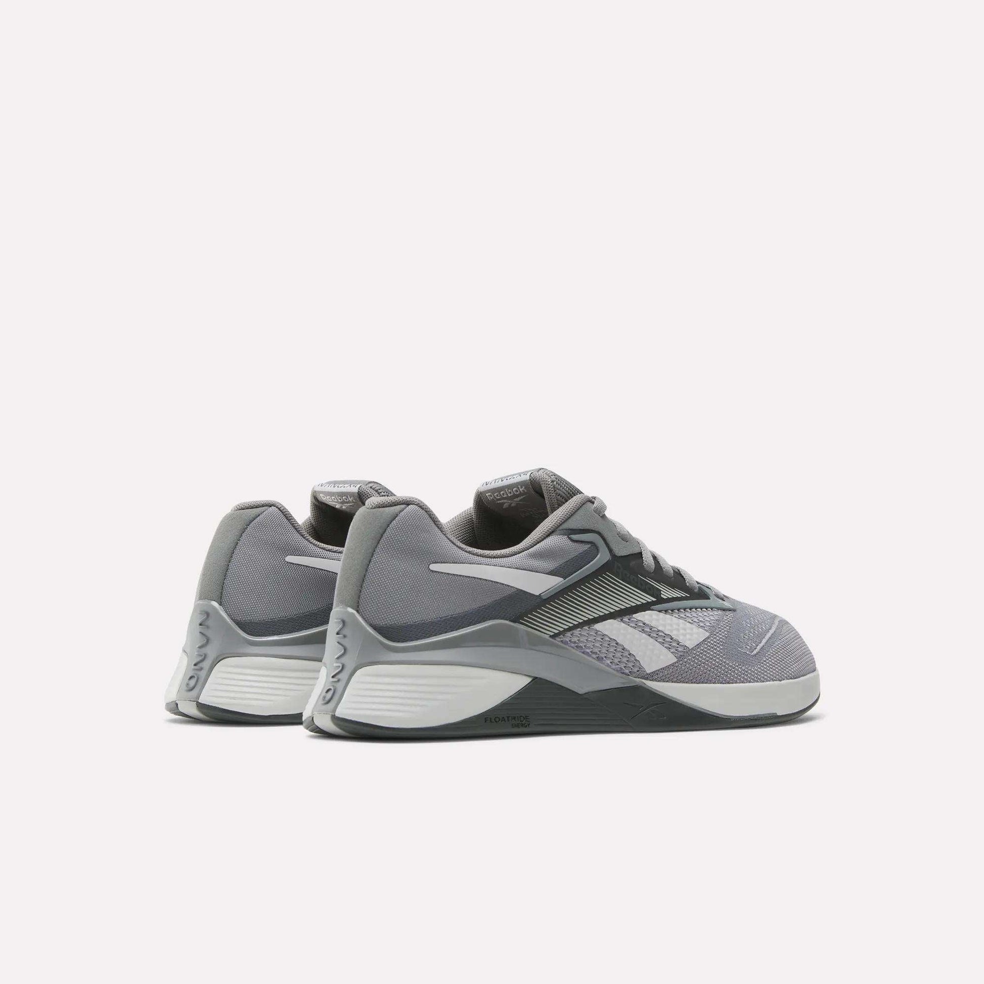 A pair of gray Reebok Nano X4 Training Shoes with white accents and black soles, featuring Floatride Energy Foam, displayed on a light background and angled to reveal the outer sides and backs.