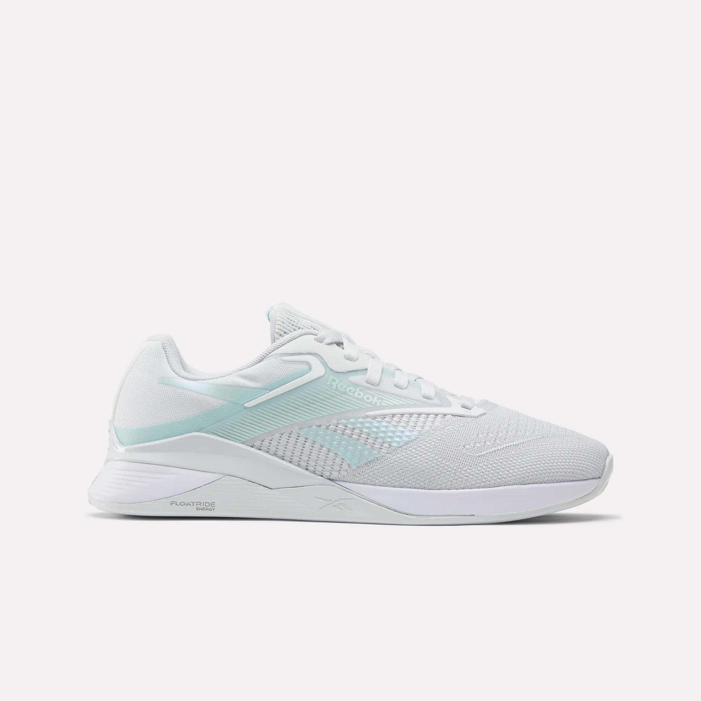 The Reebok Women's Nano X4 Training Shoes are white athletic sneakers with light blue accents, breathable mesh fabric, the Reebok logo on the side, and a flat supportive sole with Floatride Energy Foam for sports or casual use.