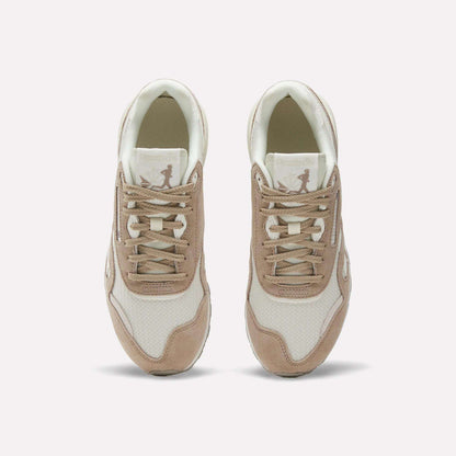 A pair of Women’s Classic Nylon 89 Shoes by Reebok in beige and white, seen from above, display laces, mesh texture, suede overlays, and a retro look with the Reebok logo on each tongue.