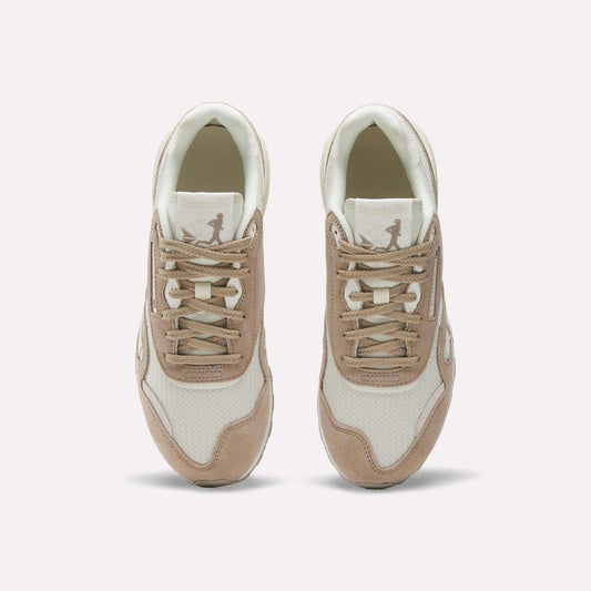 A pair of Women’s Classic Nylon 89 Shoes by Reebok in beige and white, seen from above, display laces, mesh texture, suede overlays, and a retro look with the Reebok logo on each tongue.