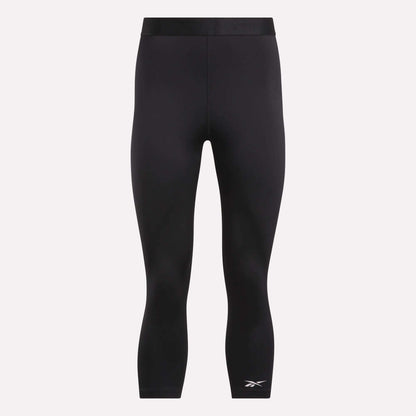 Reebok Women's ID Basketball 3/4 Compression Leggings feature a mid-rise waistband, three-quarter length, and a white logo on the lower left leg. Made from moisture-wicking fabric for comfort. Displayed on a plain light background.