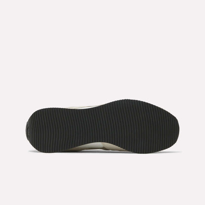 The image shows the black, ribbed outsole of Reebok R100 Shoes viewed from below on a white background, evoking classic '70s running style.