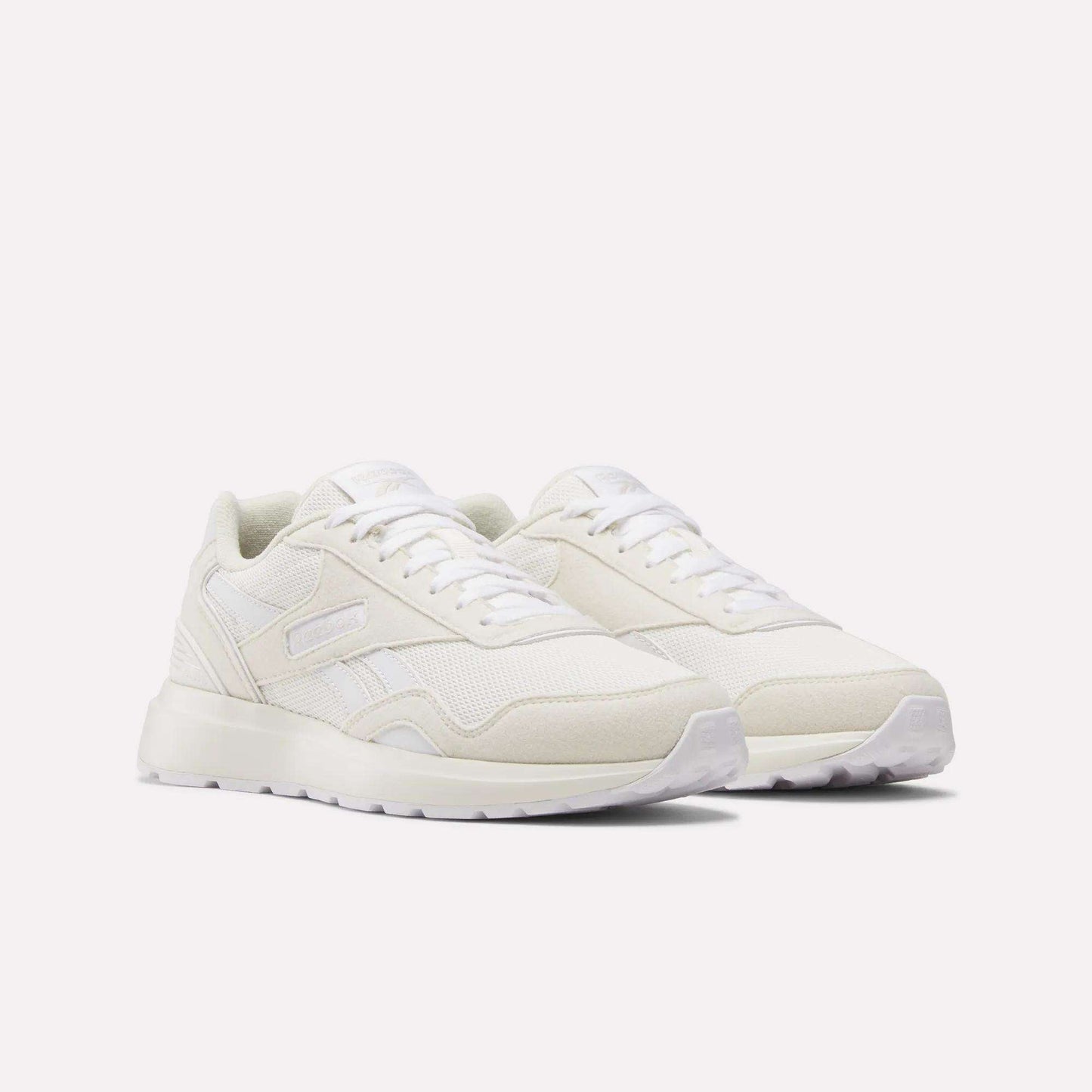 Women's GL1100 Shoes by Reebok, featuring an off-white design with lightweight mesh and suede panels, white laces, and a textured rubber sole, shown on a plain white background.
