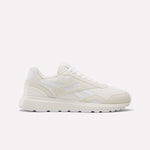 The Women's GL1100 Shoes by Reebok are white athletic sneakers with side stripes, a textured sole, and subtle branding, shown in profile on a plain white background—perfect for comfortable everyday wear.