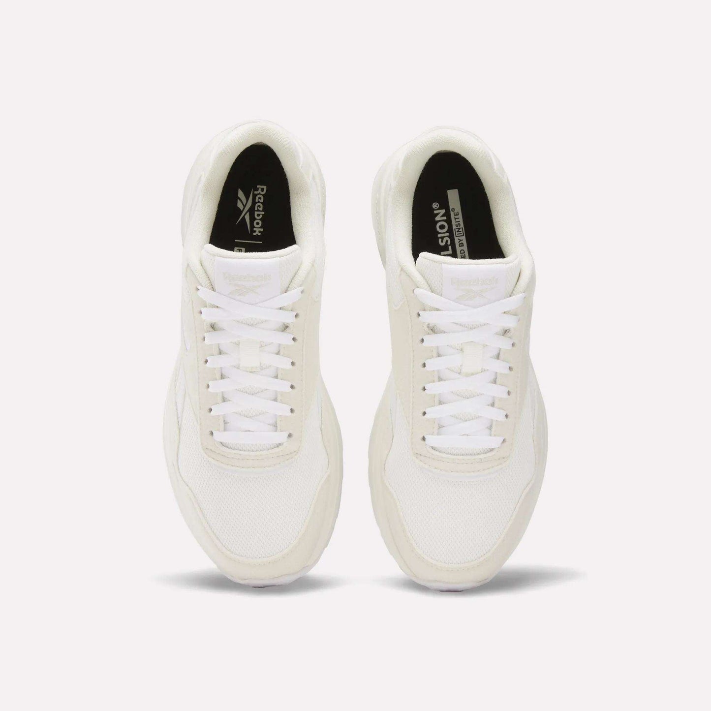 A pair of Reebok Women's GL1100 Shoes in white, seen from above, with white laces, mesh texture, and black insoles featuring Reebok branding on a plain white background—ideal for everyday wear.