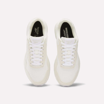 A pair of Reebok Women's GL1100 Shoes in white, seen from above, with white laces, mesh texture, and black insoles featuring Reebok branding on a plain white background—ideal for everyday wear.