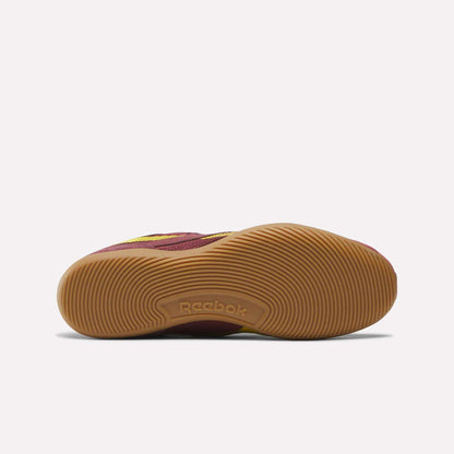 The Reebok Women's Ultra Lo Shoes are shown from the bottom, featuring a maroon upper and a textured light brown rubber sole with the Reebok logo in the center. This low-profile design ensures lightweight, all-day comfort.