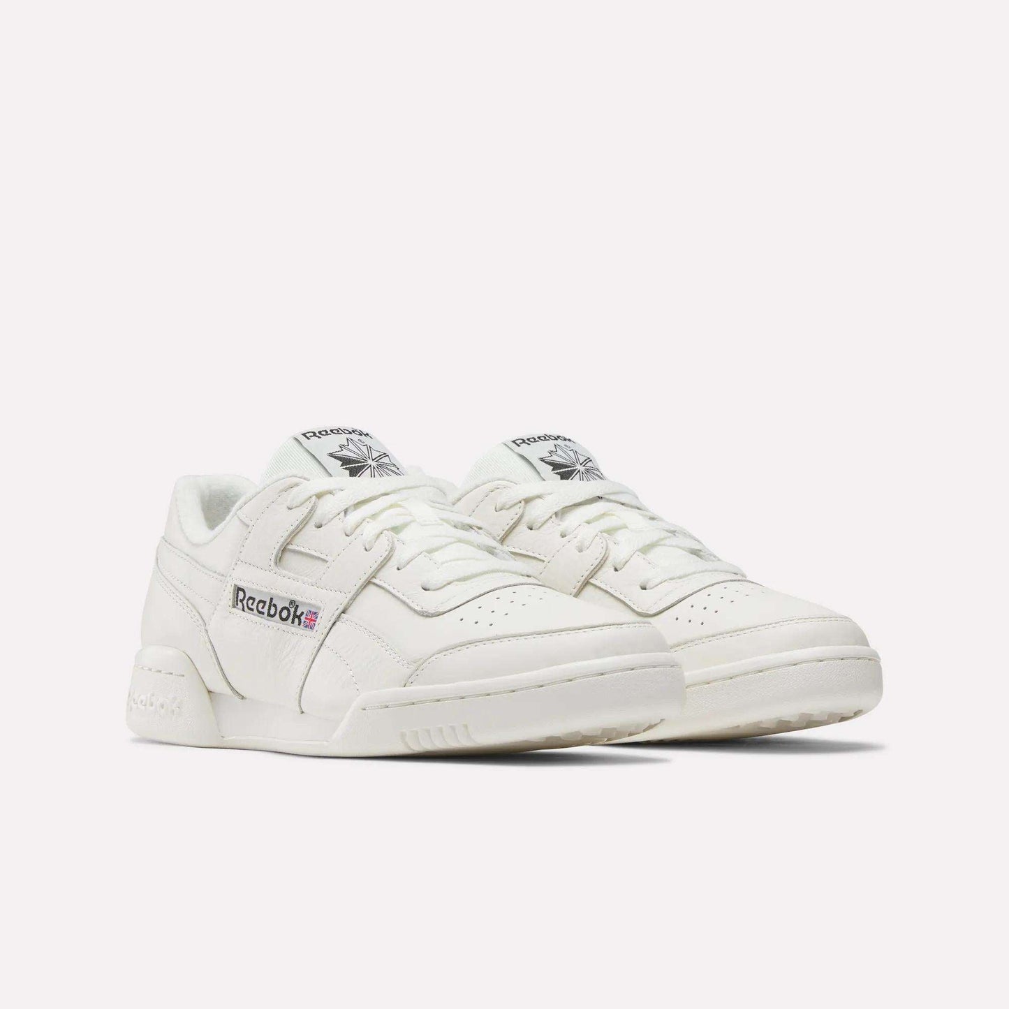 The Reebok Workout Plus Shoes are low-top sneakers in white, featuring the signature Reebok logo and Union Jack flag on the side, evoking classic '80s fitness style against a plain white background.