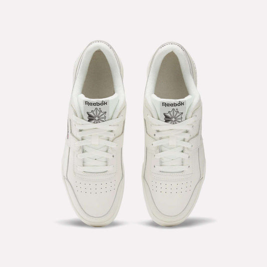 A pair of white Reebok Workout Plus Shoes viewed from above showcases classic '80s fitness style. The tops, laces, and Reebok logo on each tongue are visible, set against a plain light background.