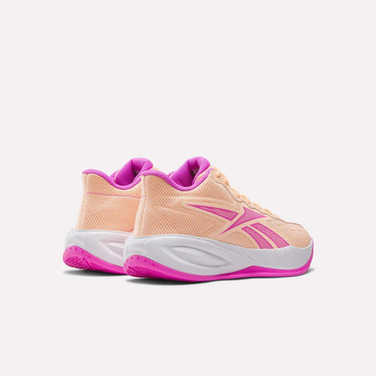 The Reebok Press Basketball Shoes in peach with pink detailing feature white midsoles, pink outsoles, and responsive EVA cushioning for all-day comfort. Shown from the back and side on a white background.