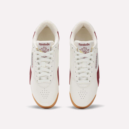 Top view of Women's Freestyle Lo Shoes by Reebok in white with maroon accents, gum soles, and logo with red maple leaf on the tongue. These women's retro sneakers are neatly laced and set side by side on a light background.