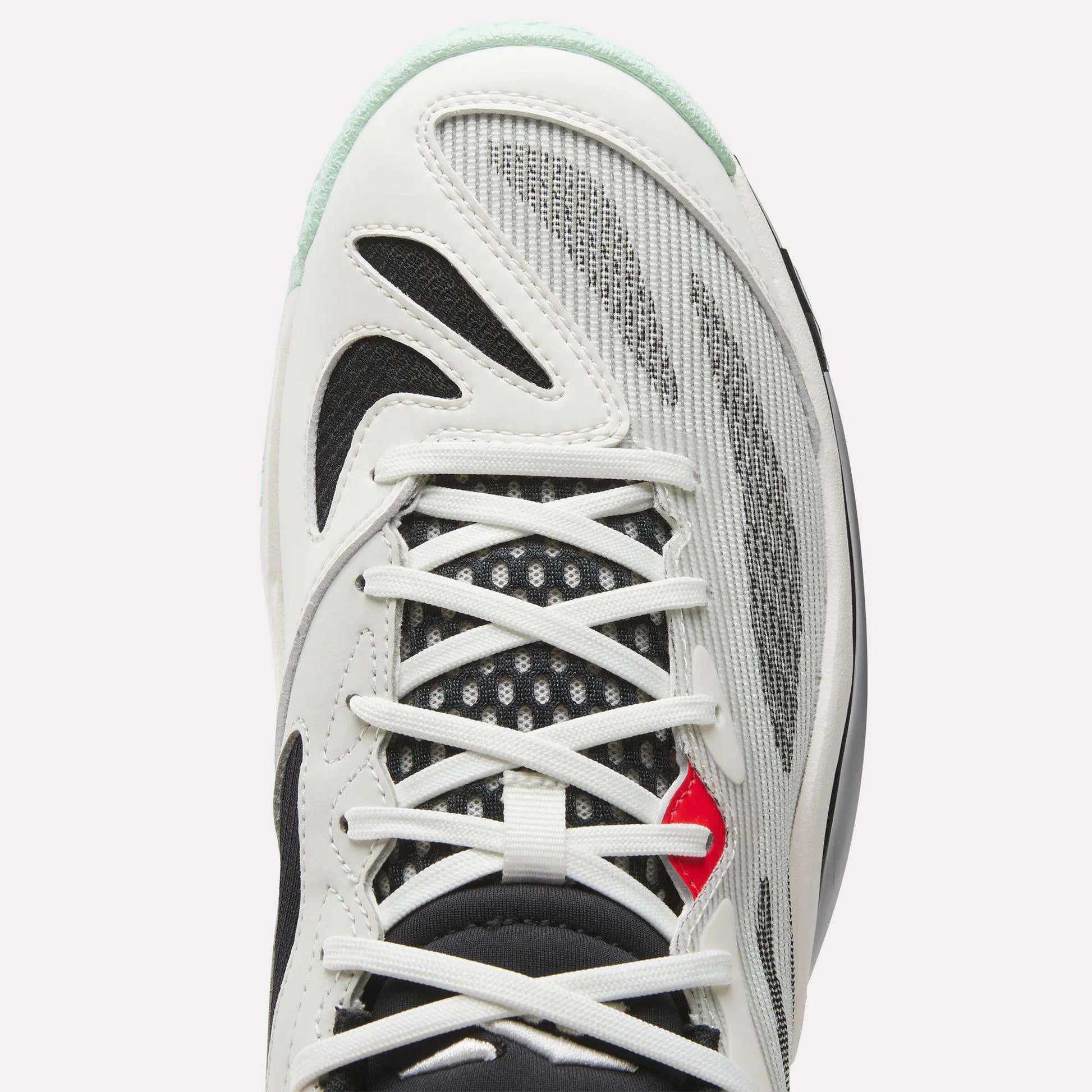 Top view of Reebok Engine A 26 Basketball Shoes with white and black overlays, gray mesh panels for stability, white laces, a small red accent by the eyelets, and a tongue featuring black and white patterned mesh.