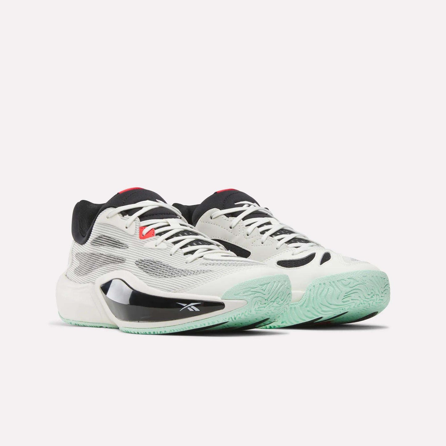 The Reebok Engine A 26 Basketball Shoes feature a white and black mesh upper, light green soles, and red accents for outstanding stability and energy return, shown on a plain white background.