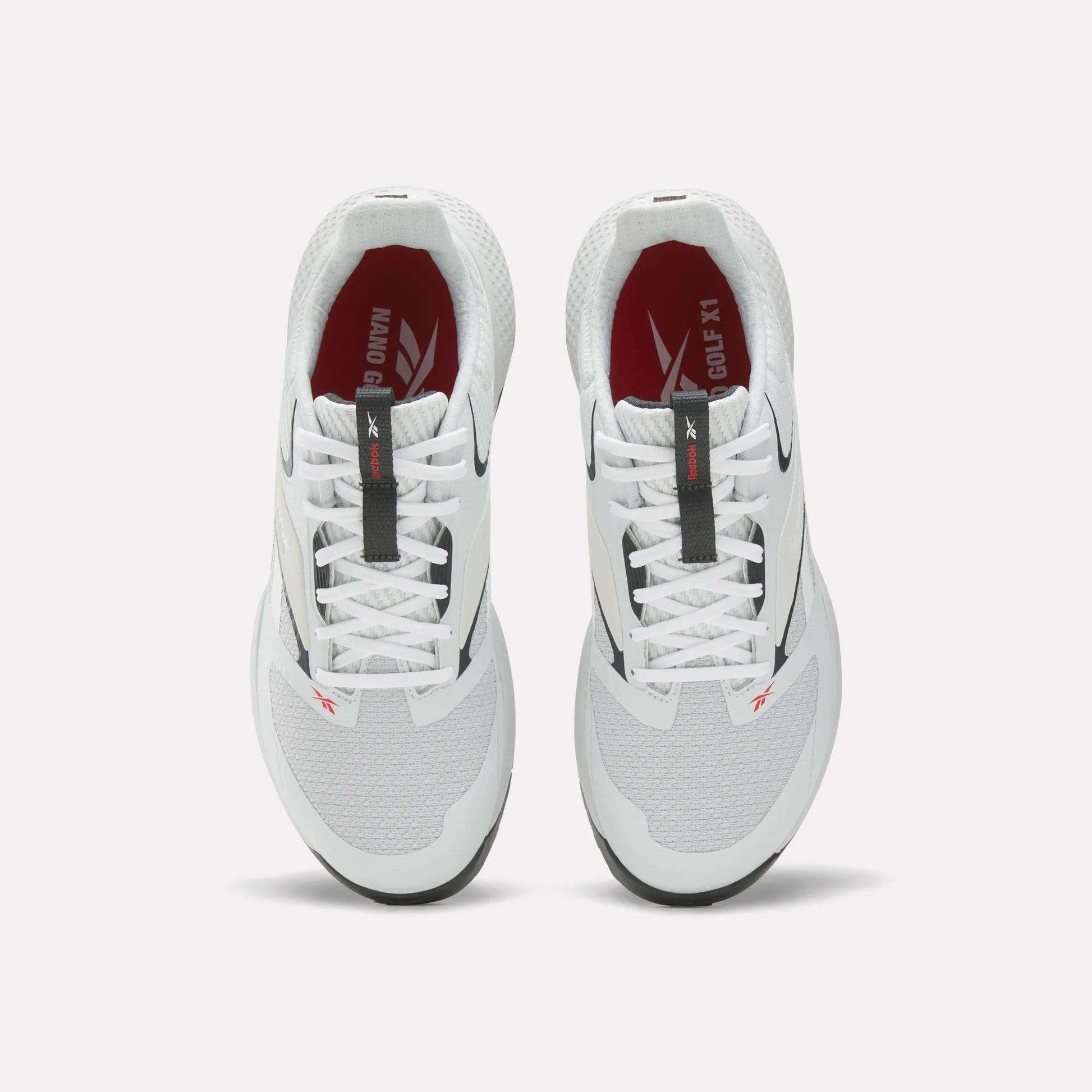 A pair of Reebok Nano Golf Shoes, viewed from above, with white mesh uppers, black and red accents, Floatride foam cushioning, lightweight FlexWeave design, white laces, and red insoles featuring white branding.