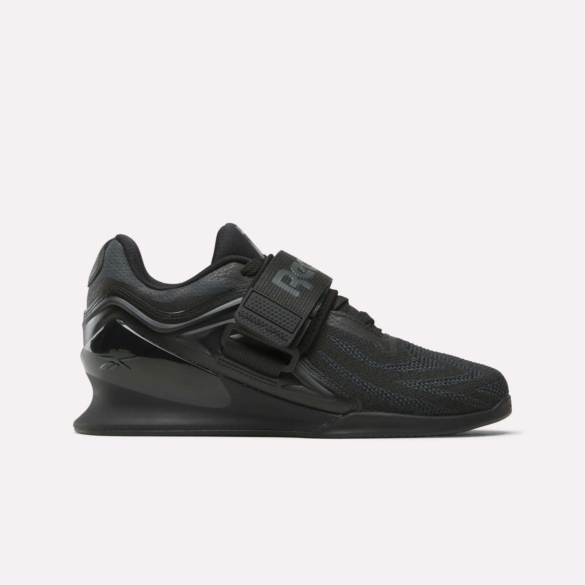 The Reebok Women's Legacy Lifter IV Training Shoes feature a thick sole, mesh upper, and wide midfoot strap, offering support and stability for weightlifting.