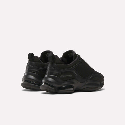 A pair of Reebok Women's DMX Series 3000 Training Shoes in black, with chunky soles, DMX 3 Technology, mesh and synthetic uppers, and subtle branding, shown on a plain light background from the back and side angles.