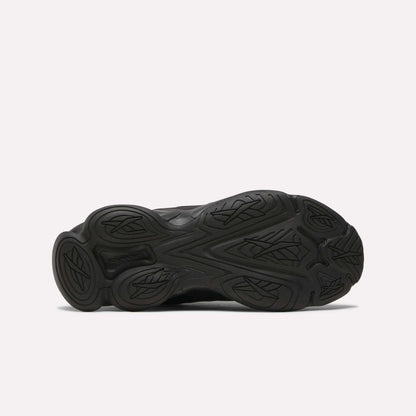 Bottom view of the Women's DMX Series 3000 Training Shoes by Reebok, showing a black textured rubber outsole with curved, leaf-like treads on a white background—ideal for walking and offering cushioned comfort.