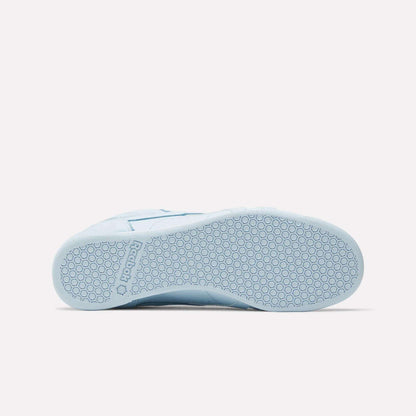 The Women's Freestyle Lo Shoes by Reebok in light blue are shown from the bottom, featuring a textured rubber sole with a hexagonal pattern and the Reebok logo embossed near the heel—ideal for everyday wear.