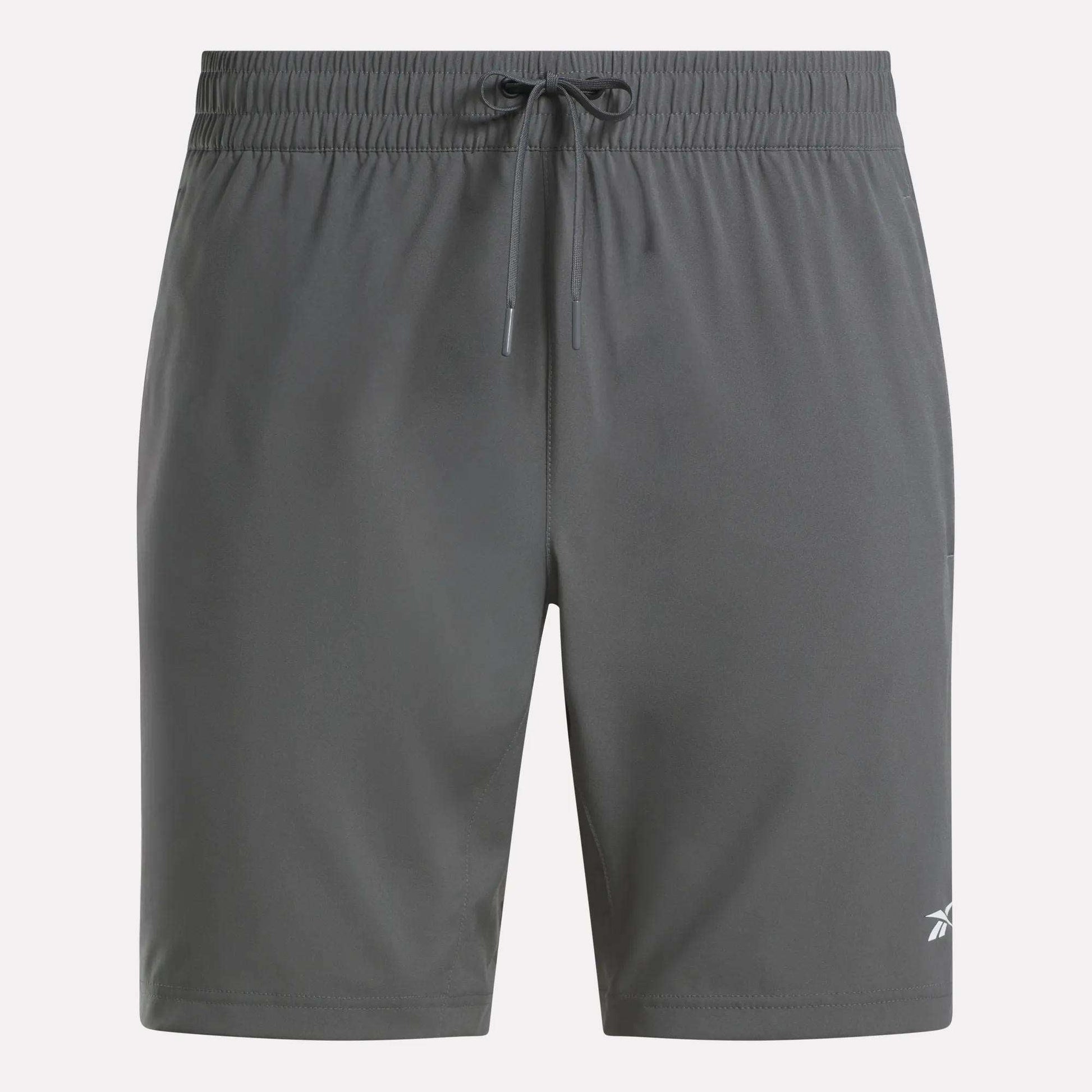 Reebok Men's Woven Shorts in dark gray feature sweat-wicking fabric, an elastic waistband with drawstring, and a small white logo on the lower left leg. The plain design is ideal for any workout.