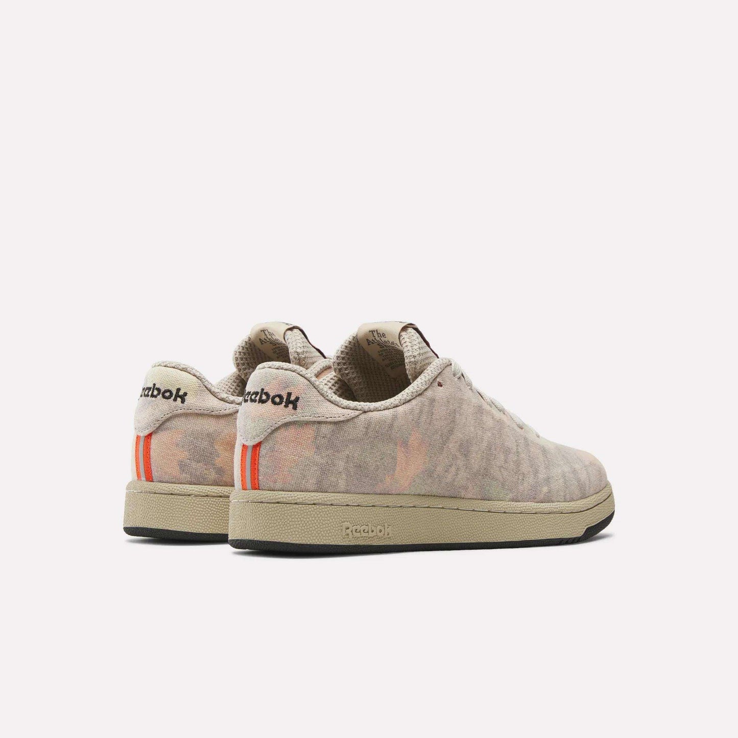 A pair of beige suede Reebok x MARKET Club C 85 Shoes featuring a subtle camouflage pattern, orange striped accents on the back, and black Reebok branding on the heel, shown against a plain white background.