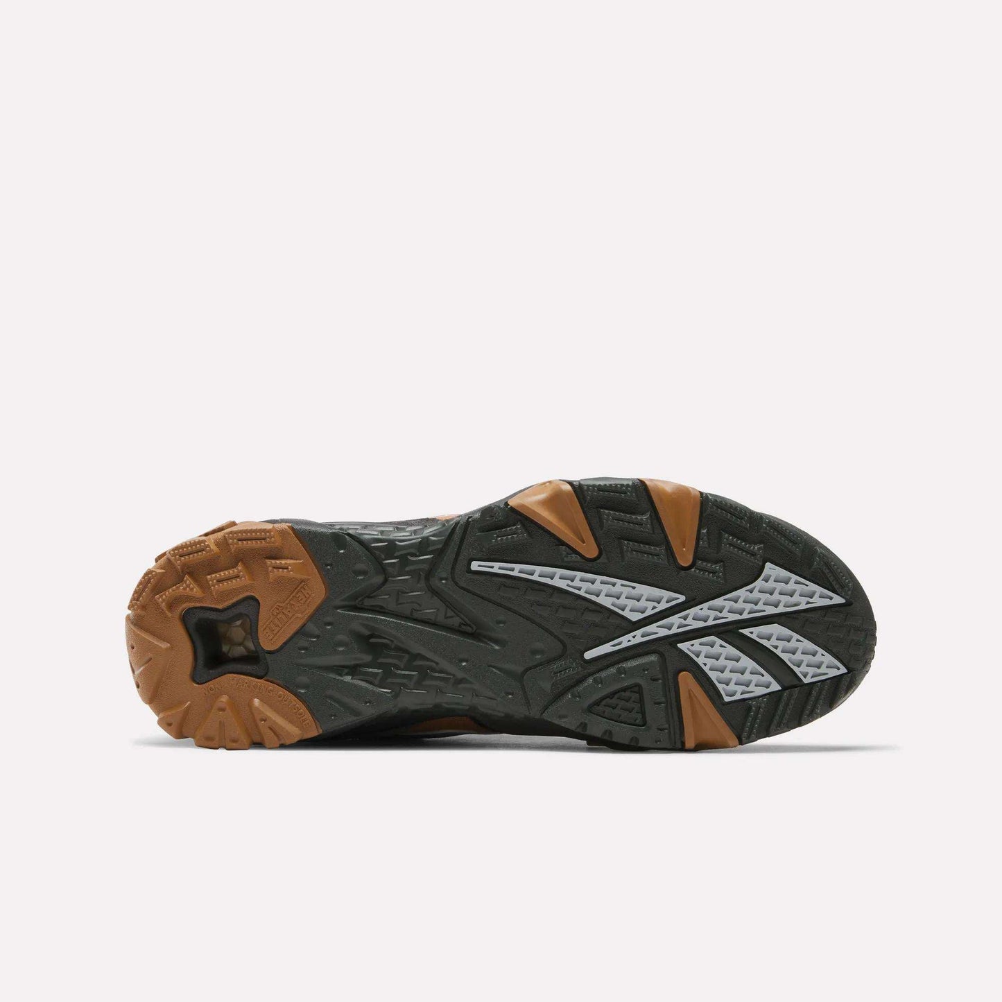 The image shows the underside of the Reebok x MARKET Preseason 94 Low Shoes, featuring a textured black sole with brown and gray accents, a large gray Reebok logo, and an angular tread pattern designed for traction.