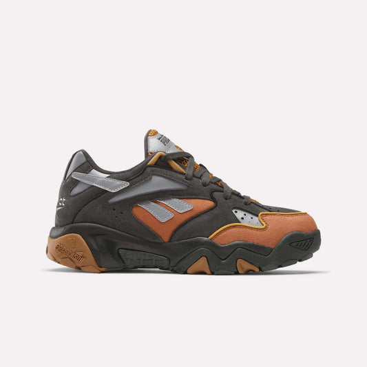 The Reebok x MARKET Preseason 94 Low Shoes by Reebok showcase a chunky sole, dark gray, brown, and orange panels with silver accents and gray laces—presented on a plain white background.