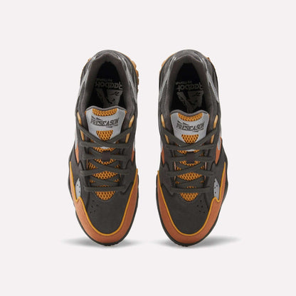 Top view of Reebok x MARKET Preseason 94 Low Shoes in dark gray, orange, and yellow, featuring mesh details and “PRESEASON” on the tongue, shown against a plain white background.