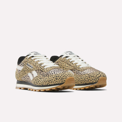 A pair of Reebok Classic AZ Shoes - Little Kids are shown with a tan, black, and brown cheetah print, white laces and logos, black lining, and a light brown rubber sole against a plain white background.