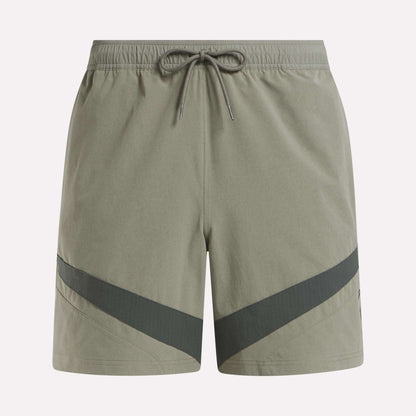 Reebok Woven Basketball Shorts in light olive green feature an elastic waistband with drawstring, dark diagonal stripes near the hem, and smooth, lightweight fabric—perfect for active wear or basketball enthusiasts.