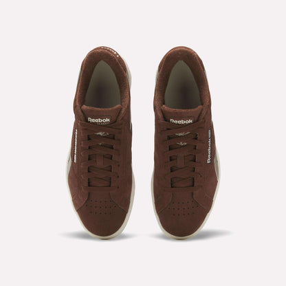 A pair of Reebok Club C Grounds UK Shoes in brown suede viewed from above, with white soles, laces, and Reebok branding on the tongue and side, delivering a classic vintage tennis style.
