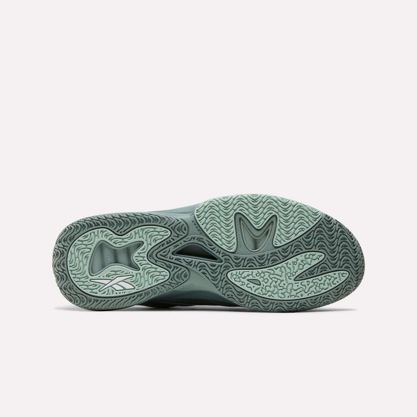 The image shows the light green, textured sole of the Reebok Angel Reese 1 Basketball Shoe, featuring curved patterns, a stylized heel logo, and the Energy Return System, displayed on a plain white background.