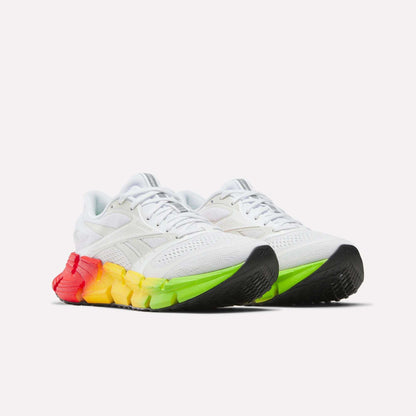 The Reebok Women's FloatZig 2 SoleMates Running Shoes feature chunky soles fading from red to yellow to green, black accents on the toe and heel, and a lightweight foam midsole for extra comfort.