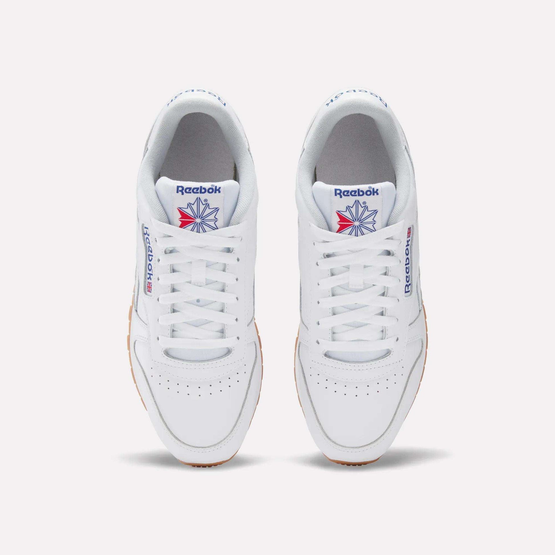 A pair of Reebok Classic Leather Shoes in white, seen from above, with white laces, a gum sole, and the iconic blue and red logo—these retro Reebok sneakers deliver timeless style.