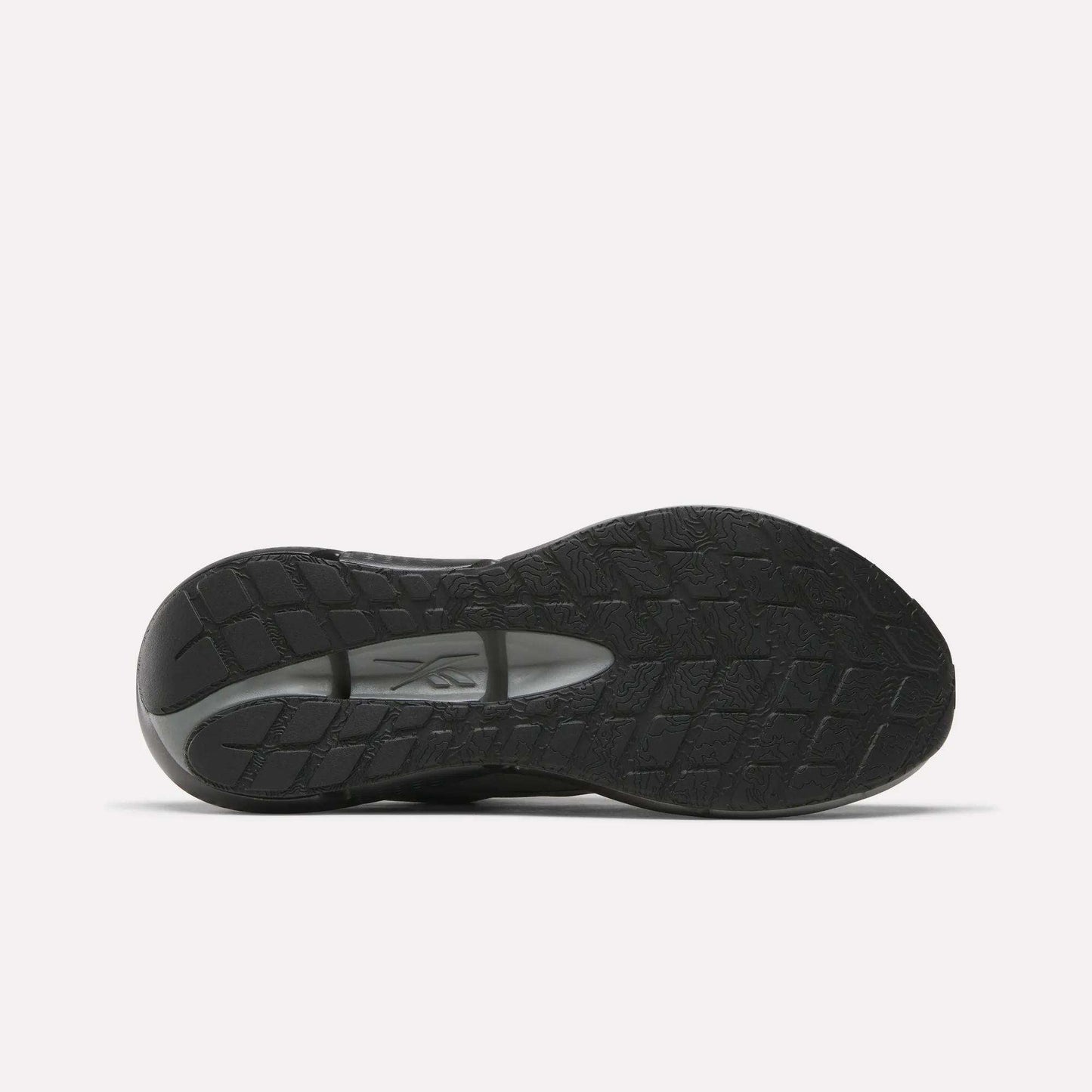 The image displays the black rubber sole of Reebok Men's Zignition Running Shoes, featuring a textured tread and visible brand logo at the midfoot, set against a plain white background.