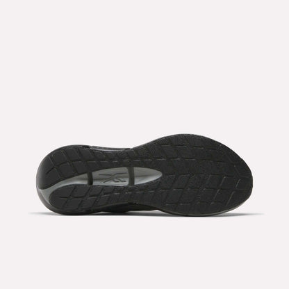 The image displays the black rubber sole of Reebok Men's Zignition Running Shoes, featuring a textured tread and visible brand logo at the midfoot, set against a plain white background.