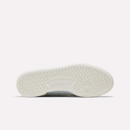 The white sole of the Reebok Women's Club C Revenge Shoes is shown from the bottom, featuring a herringbone tread pattern and an embossed Reebok logo at the center—highlighting vintage court-inspired style in women’s footwear.