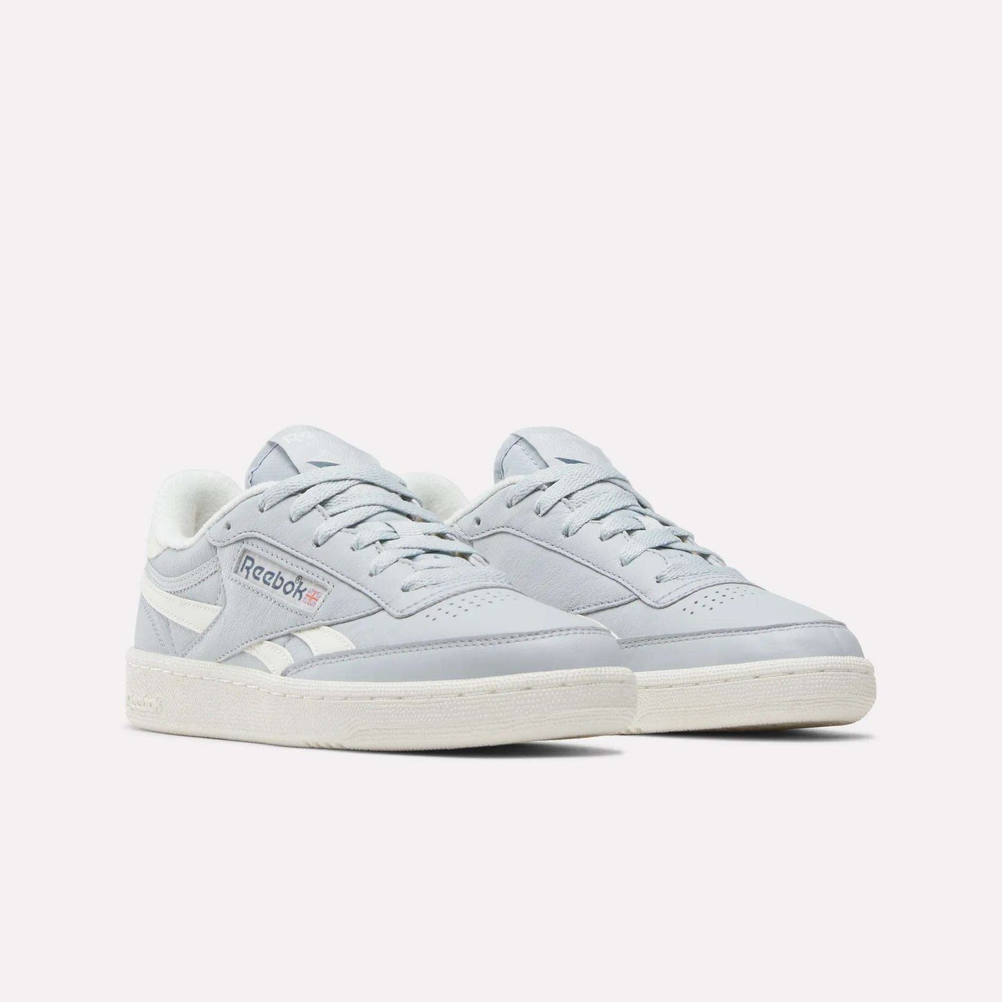 A pair of Women's Club C Revenge Shoes by Reebok in light gray, featuring white soles and white accents, are displayed on a plain white background—offering the perfect blend of vintage court style and casual women's footwear.